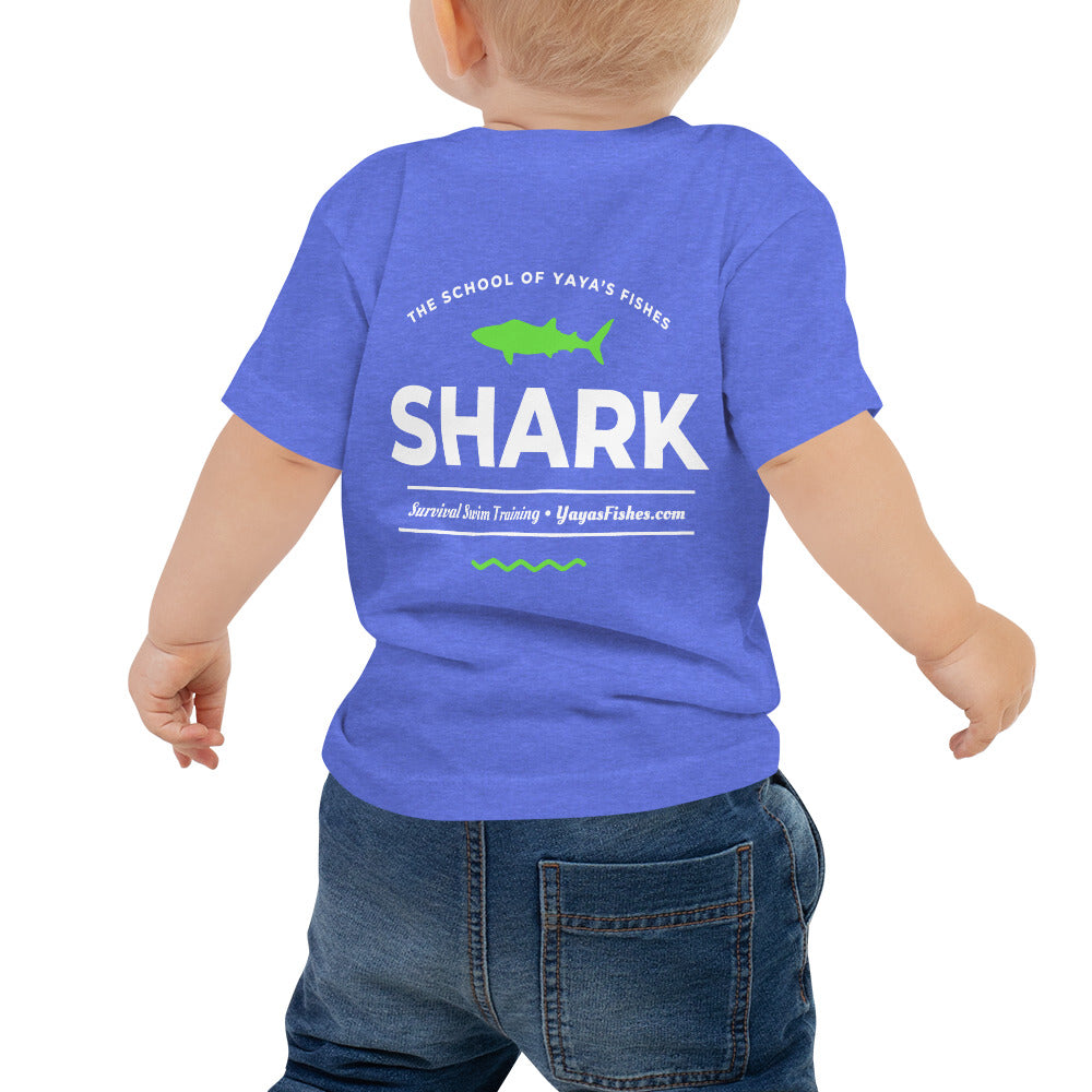Description: Bright Blue Tee shirt with The School of Yaya’s Fishes logo on the front, and white font on back with green shark and design. Font: The School of Yaya’s Fishes. SHARK. Survival Swim Training. YayasFishes.com.